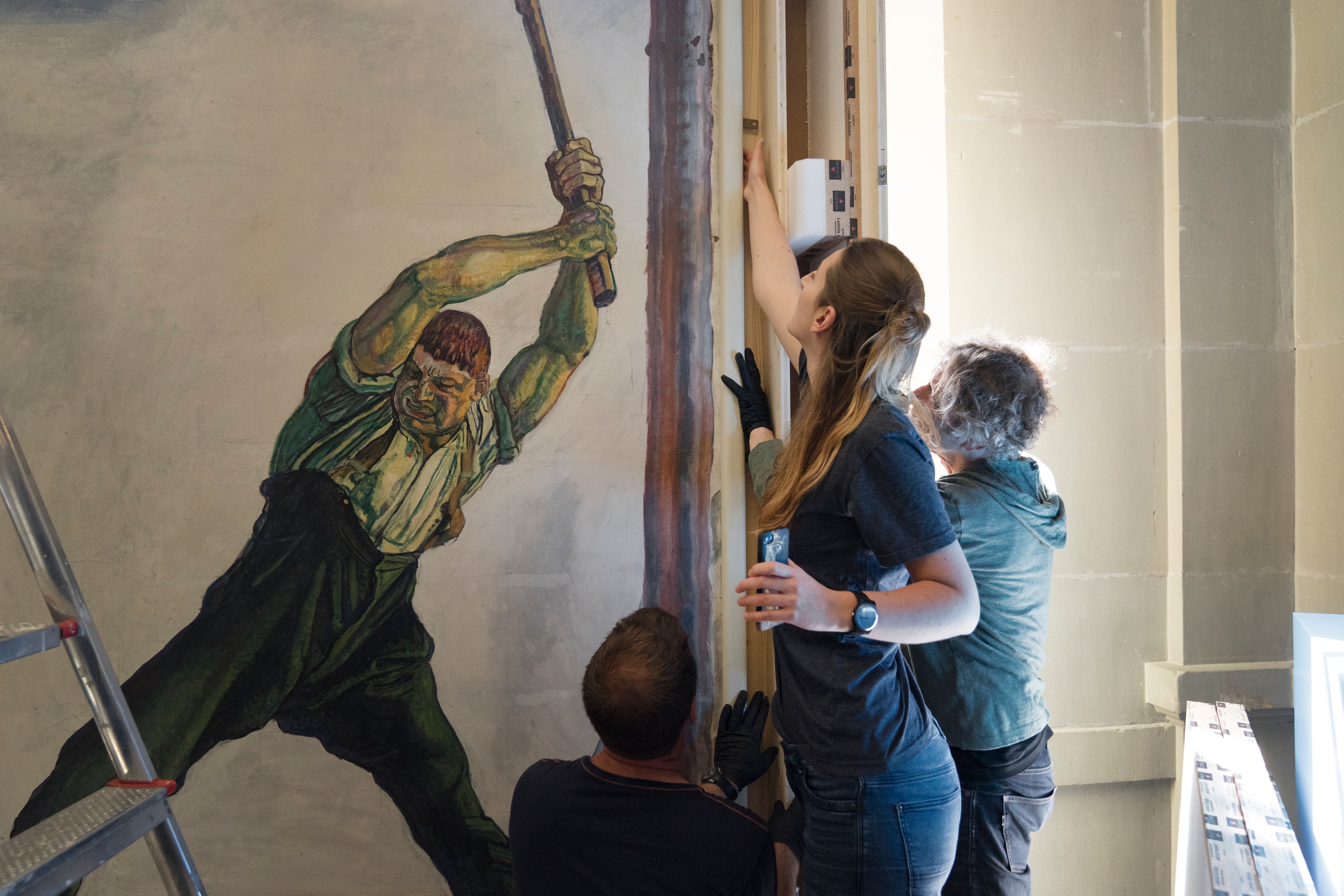 Ein Bild wird für eine Ausstellung aufgehängt